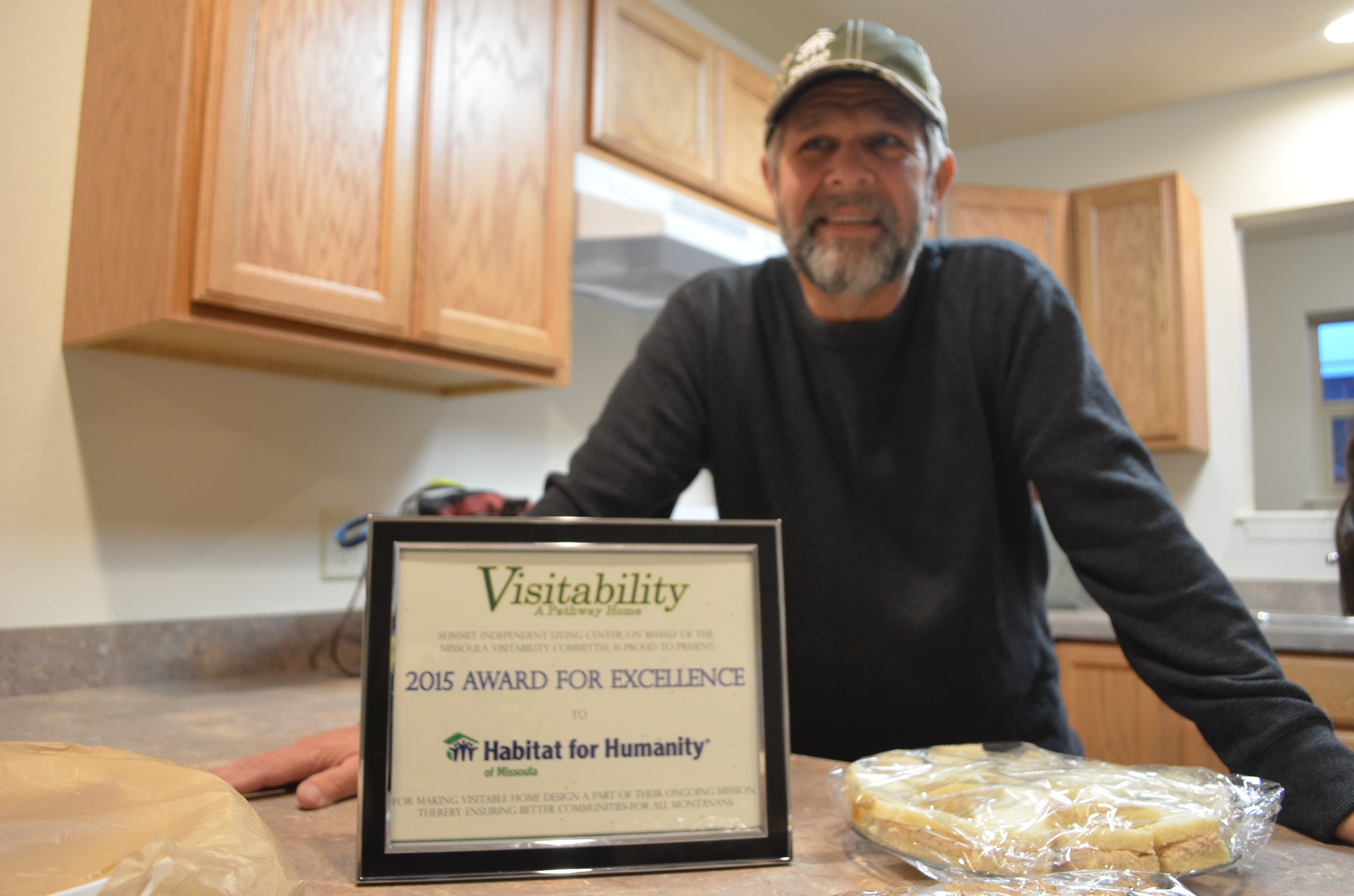 2015 Award for Excellence sitting on a counter in front of Habitat for Humanity's build team leader.