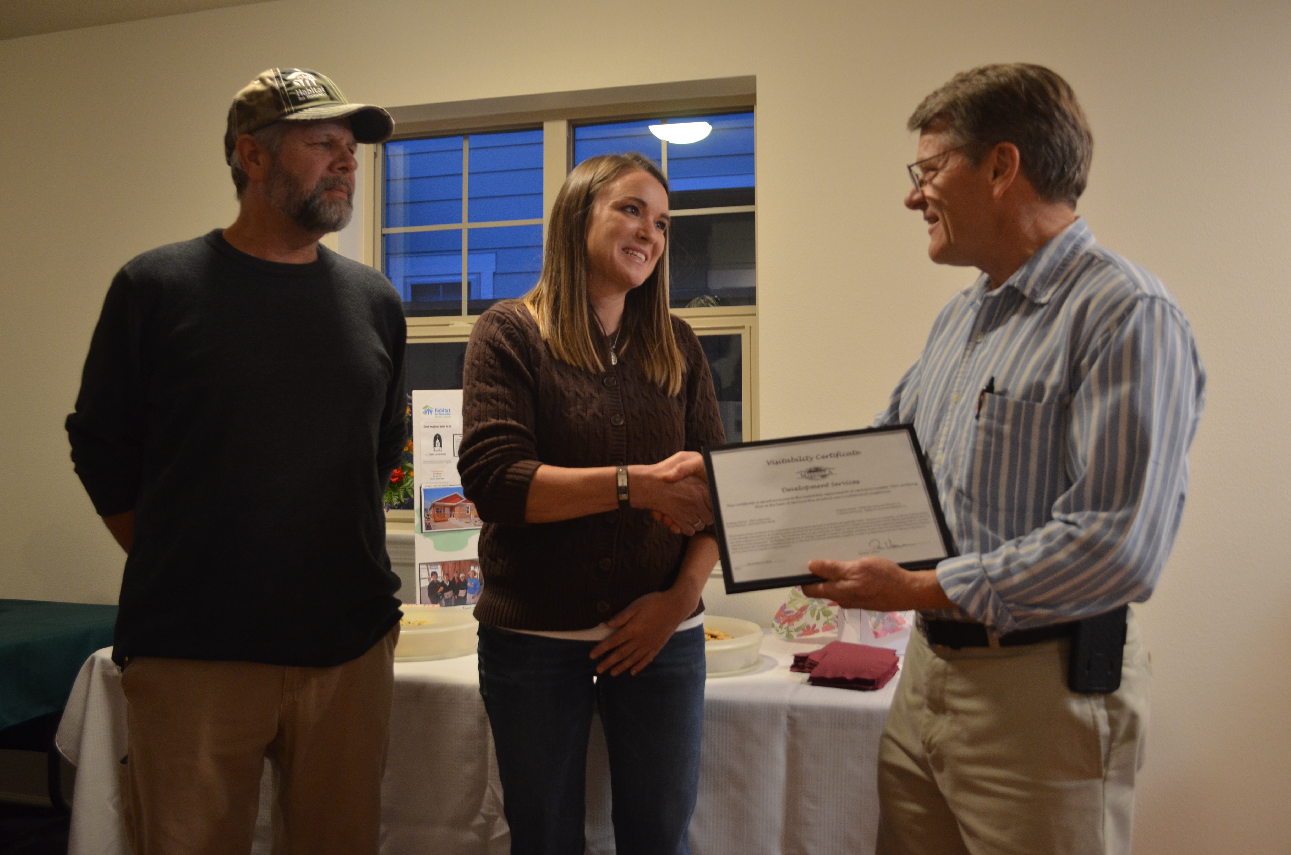 City employee Don Verrue shaking the hand of the new home owner.