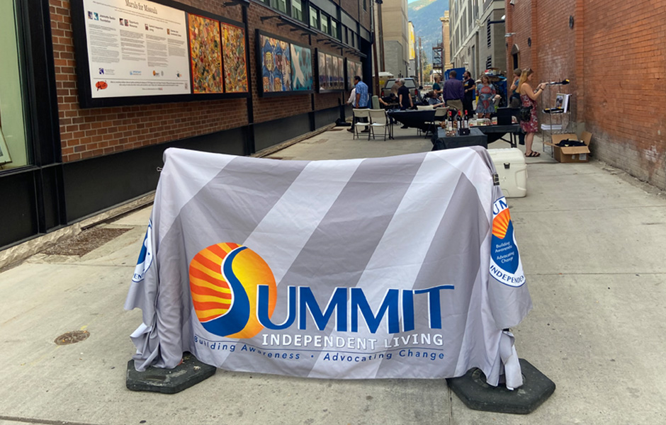 The Summit tablecloth is hung up in the front of the alleyway, and the crowd mingles behind it