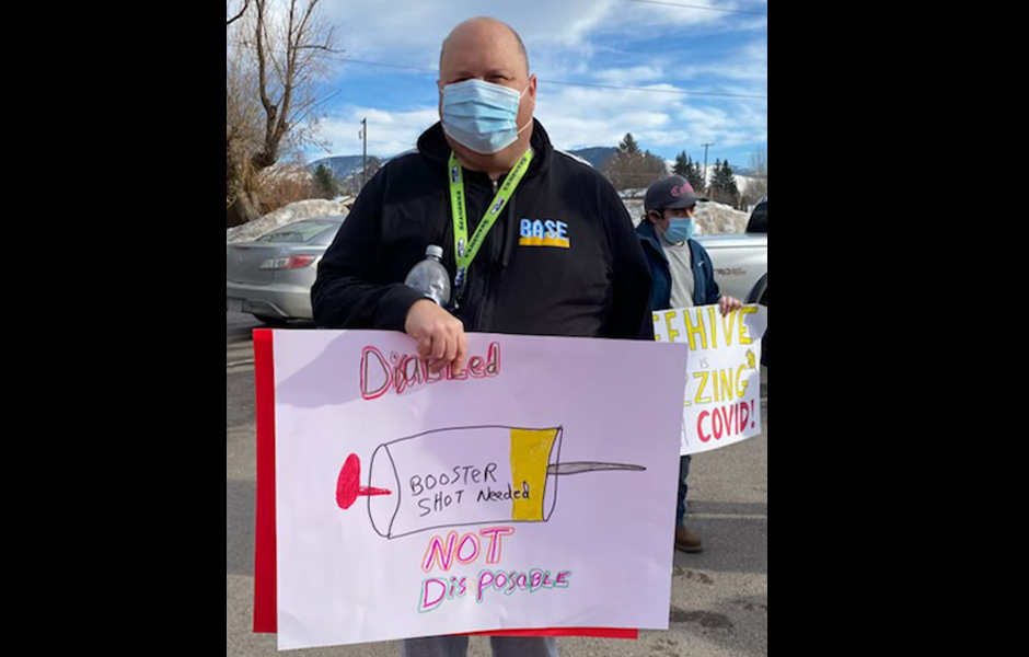 Jason holds a sign saying "Disable, not disposable"
