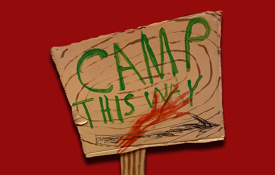 A cardboard sign says "Camp this Way" with an arrow pointing to the right