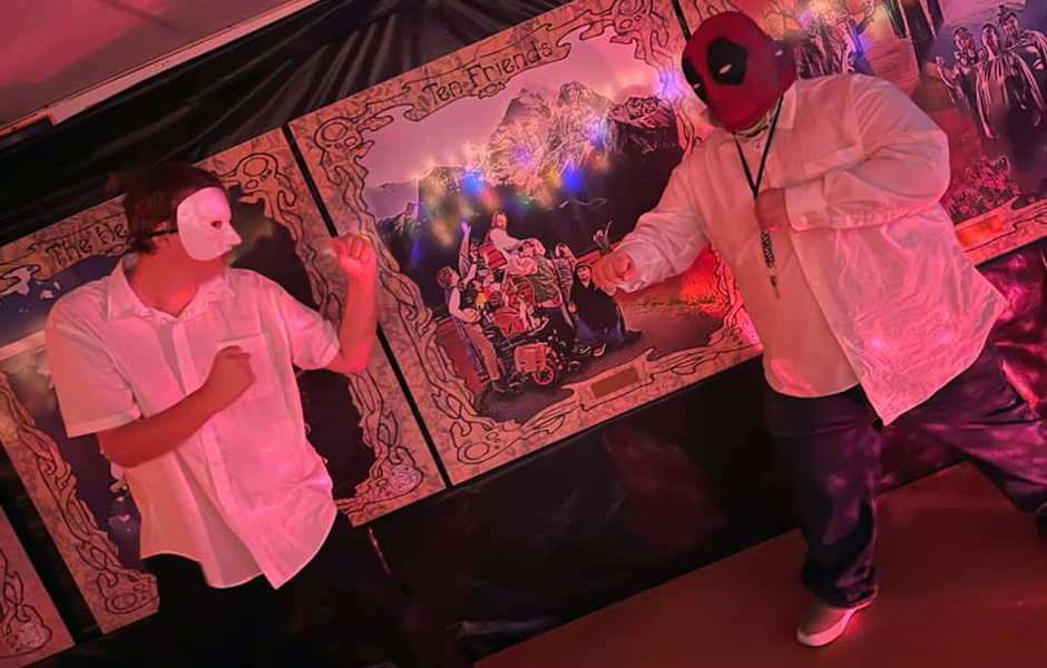 Ethan in a Phantom of the Opera mask, and Bobby in a Deadpool mask pretend to fight each other
