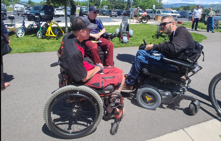 A group of individuals in wheelchairs engage in conversation together