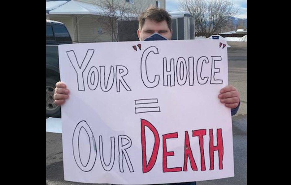 Bobby holds a sign saying "your 'choice' = our death"