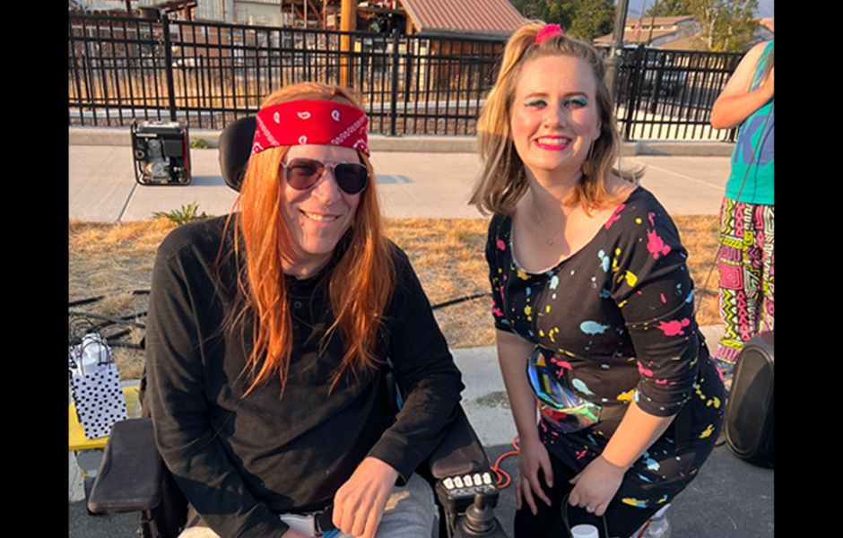 Mark, wearing a red bandana and long rocker-style hair poses for the camera with Madison