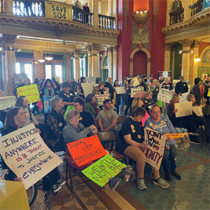 Disability advocates crowd the Capitol rotunda in Helena, many holding signs