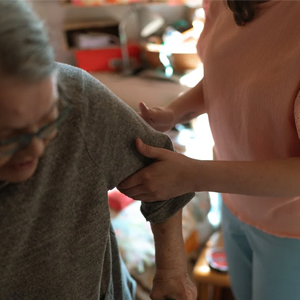 A caregiver helping an older woman with a disability